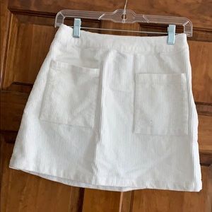 White, double-pocketed, corduroy skirt.